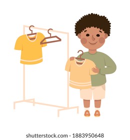 Niño que cuelga ropa en los guardas de ropa, niño que ayuda a sus padres con trabajo en casa o que hace tareas domésticas ilustraciones de vectores de dibujos animados