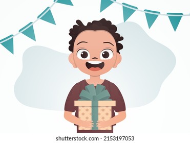 A cute boy is holding a box with a bow in his hands. Birthday. Cartoon style. Vector illustration