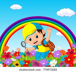 Cute boy holding magnifying glass in a flower garden with rainbow