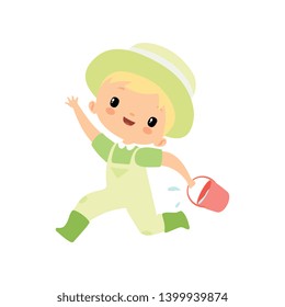 Cute Boy in Overalls, Rubber Boots and Hat Running with Bucket Full of Water, Young Farmer Cartoon Character Engaged in Agricultural Activities Vector Illustration