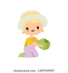 Cute Boy in Overalls, Rubber Boots and Hat Holding Head of Cabbage, Young Farmer Cartoon Character Engaged in Agricultural Activities Vector Illustration