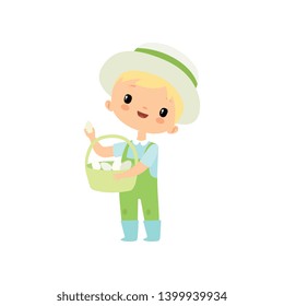 Cute Boy in Overalls, Rubber Boots and Hat with Basket of Fresh Eggs, Young Farmer Cartoon Character Engaged in Agricultural Activities Vector Illustration