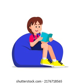 cute boy reading a book and sitting on a beanbag