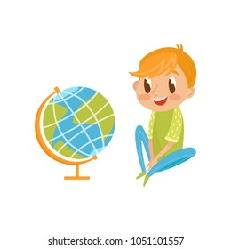 Cute boy sitting on the floor and looking at the globe, education and knowledge concept, colorful cartoon character vector Illustration on a white background