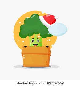 Cute broccoli mascot in a box wearing a Christmas hat