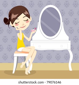 Cute brunette sitting in front of dressing table smelling perfume aroma from her wrist