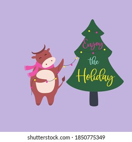 Cute bull character with scarf, decorates Christmas tree. Enjoy the holiday quote. Christmas hand drawn vector animal with garland. Winter holiday greeting card, poster design. New year sign cow 2021 