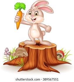 Cute bunny holding carrot on tree stump