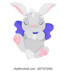 A cute bunny is lying on its back with a blue bow on its neck. Isolated image of gray little hare on white background