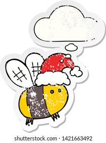 cute cartoon bee wearing christmas hat with thought bubble as a distressed worn sticker