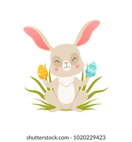Cute cartoon bunny sitting on the grass holding eggs, funny rabbit character, Happy Easter concept cartoon vector Illustration
