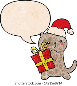 cute cartoon cat carrying christmas present with speech bubble in retro texture style