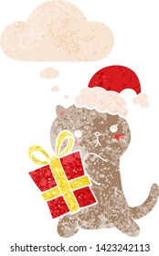 cute cartoon cat carrying christmas present with thought bubble in grunge distressed retro textured style