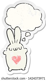 cute cartoon rabbit with love heart with thought bubble as a distressed worn sticker