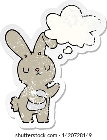 cute cartoon rabbit with thought bubble as a distressed worn sticker