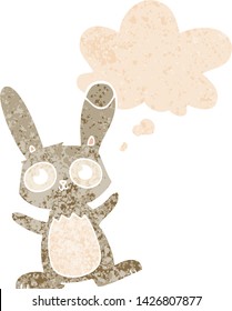 cute cartoon rabbit with thought bubble in grunge distressed retro textured style