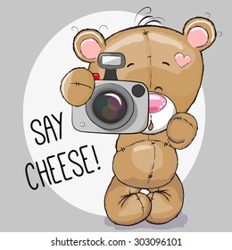 Cute cartoon Teddy Bear with a camera on a gray background
