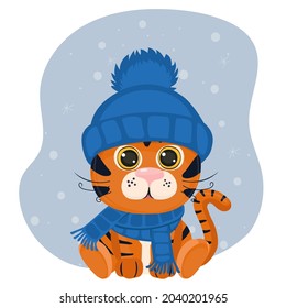 Cute cartoon tiger cub in a blue winter hat and scarf. Winter vector illustration on a blue background with snow.