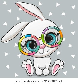 Cute Cartoon white Rabbit in multicolored glasses on a gray background