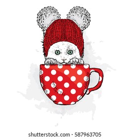 Cute cat in a hat sits in a cup. Vector illustration for a card or poster.