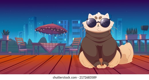 Cute cat sitting on wooden terrace with night view. Funny pet wear trendy clothes and glasses on patio area with table and chairs under umbrella on cityscape background, Cartoon vector illustration