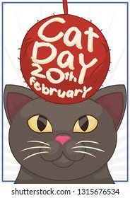 Cute cat staring and planning to play with its toy wool ball with reminder date to celebrate Cat Day in this February 20.