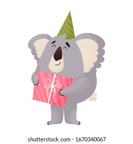 Cute cheerful Koala in a festive cap holds a gift.