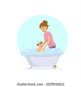 cute cheerful mother woman bathing her child in a bathtub with bubbles foam