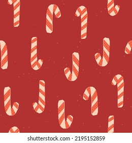 Cute Christmas seamless pattern with candy canes on red background. Vector retro repeat with traditional Christmas sweets. Illustration for fabric, textile, wrapping paper, wallpaper, and others.