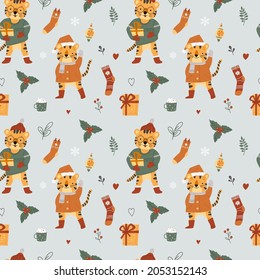 Cute Christmas seamless pattern. Image of winter clothes, New Year's tigers. Blue background. Vector illustration.