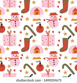 Cute Christmas seamless pattern. Pink, red, green and orange pattern with present box, snowman, glass ball dollhouse, candy, tree toy, sock. Flat vector illustration
