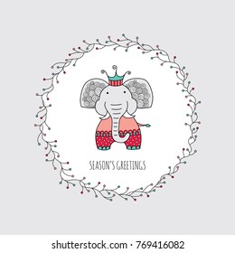 Cute Christmas themed elephant surrounded by a wreath with branches and lights and the words season's greetings, vector illustration.