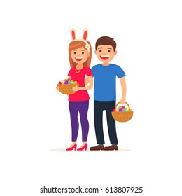 Cute couple. Easter day. Girl and man holding basket with painted eggs.