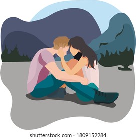 Cute couple in love is sitting near the mountains on vacation.