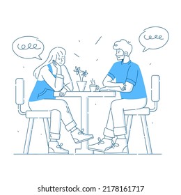 Cute couple sitting at table, drinking tea or coffee and talking. Young funny man and woman at cafe on date. Dialog or conversation between romantic partners.