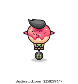 The cute doughnut character is riding a circus bike