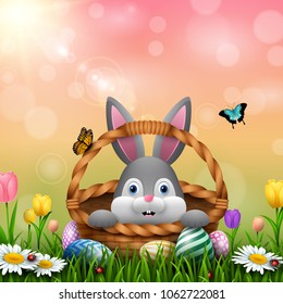 Cute Easter bunny in a basket with colorful eggs on the grass