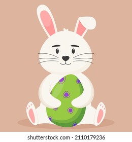 Cute Easter bunny with an Easter egg in its paws. Easter concept