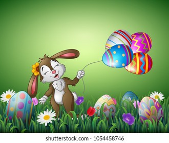 Cute easter bunny holding an Easter egg balloon in a field