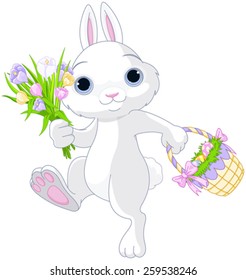 A cute Easter bunny holds full basket of colored eggs and bouquet of flowers