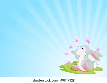 A cute Easter bunny sitting on the spring meadow.
