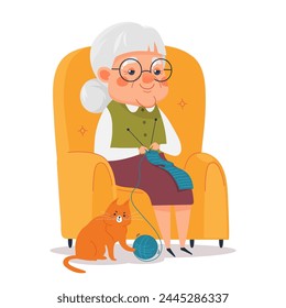 Cute elderly woman knitting scarf while sitting in an armchair. Grandma doing a hobby, cat playing with a ball of thread