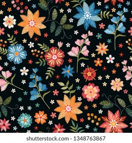 Cute embroidery seamless pattern with colorful wild flowers on black background. Floral fashion design for fabric and textile. Embroidered summer meadow.