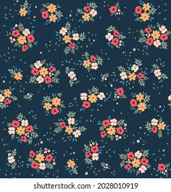 Patrón floral lindo en las flores pequeñas. Textura vectorial sin inconvenientes. Elegante plantilla para impresiones de moda. Impresión con flores rojas, amarillas y blancas pequeñas. Fondo azul oscuro.