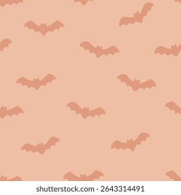 Cute flying bat silhouette seamless vector pattern in soft orange tones for Halloween or autumn decor