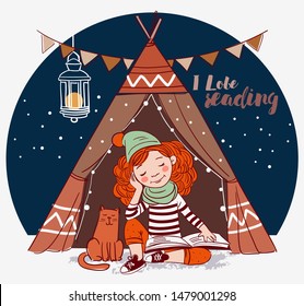 Cute, funny girl sitting inside a tepee tent and reading a book. Little girl with a cat 