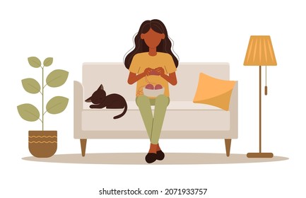 Cute girl is knitting with a cat sitting on the couch. Needleworker. Room interior Houseplant and floor lamp. Vector illustration in flat style