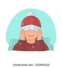 Cute girl pulled her hat over her eyes and rejoices in the falling snow