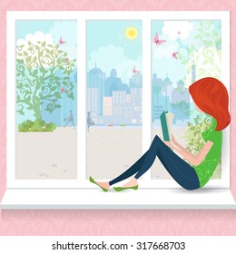 Cute girl is reading a book on a window sill.