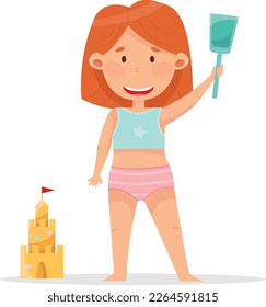 Cute girl with red hair building sand castle